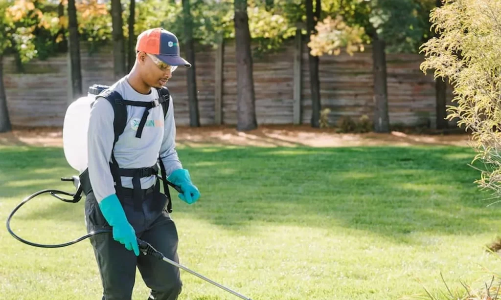 lawn squad employee spraying on lawn